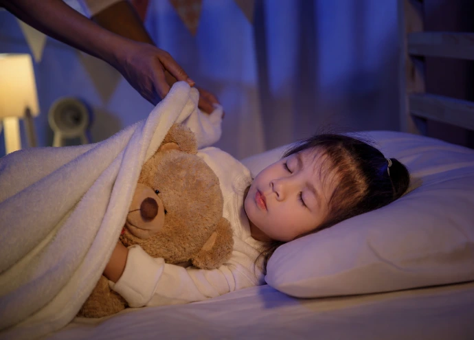 Jeune enfant dormant avec son doudou